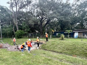 Concrete crew placing ditch pavement around a drainage structure (10-11-2023 photo)