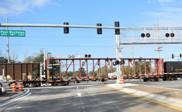 A train passes over Sam Allen Road on January 16 as crews work to prepare the intersection to reopen to traffic