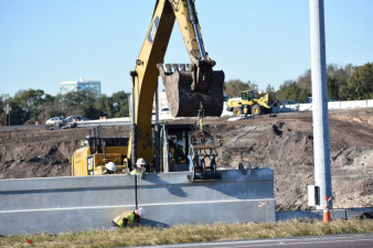 Workers install wall segments along eastbound SR 60 at the entrance ramp to northbound I-75 on January 22, 2020