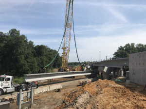 Workers prepare a beam to be lifted into place to widen the ramp bridge over Sligh Avenue. (4/6/19 photo)