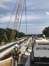 Workers direct a beam into place over Sligh Avenue. This bridge is being widened to create a two lane ramp. (4/6/19 photo)