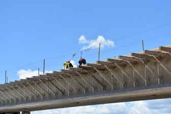 Workers on the flyover bridge that will take westbound Overpass Road traffic onto southbound I-75 (photo 7/6/2022)
