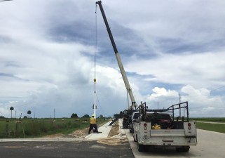 Installing a light pole along new westbound SR 52 roadway (6/23/2021 photo)