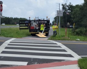 Installing signs at a shared use path crosswalk (July 2023 photo)