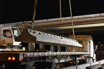A concrete beam is lifted by crane off a transport truck at SR 60 and I-275 (3/21/2020 photo)