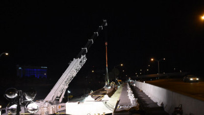 A car on northbound I-275 passes by workers installing bridge beams over SR 60 (3/21/2020 photo)