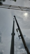 A crane is holding the pole as it is installed (8/17/2022 photo)