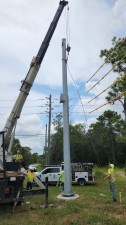 A crane holds the pole in place (8/17/2022 photo)