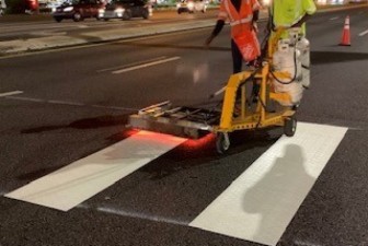 Workers install thermoplastic crosswalk striping (4/8/2021 photo)