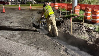 Compacting the asphalt curb pad at the NE corner (August 2026 photo)
