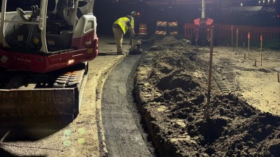 Compacting the placed asphalt curb pad (August 2026 photo)