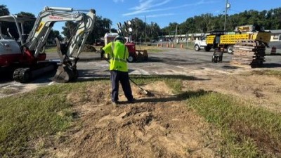 Contractor hand grading prior to sod placement (July 2026 photo)
