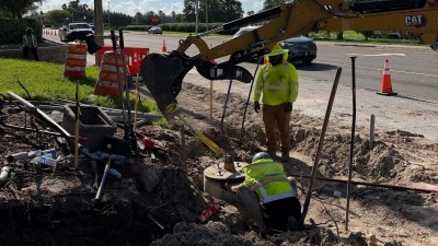 Installing precast ped pole base at the SW corner (August 2026 photo)