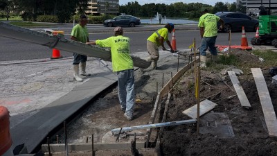 Pouring the sidewalk at the SE corner (August 2026 photo)