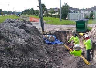 Utility workers relocate a gas main to make room for drainage structures (6/30/2021 photo)