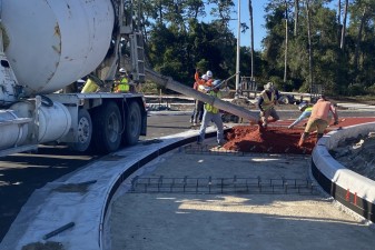 Crews paving the red concrete truck apron in the roundabout at US 98/US 301/7th Street (11-13-2025 photo)