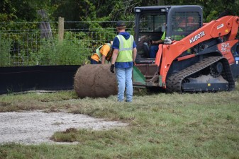 Workers place sod in a storm water drainage pond on the west side of the Ayers Road extension. (8/27/2021 photo)