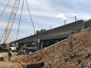 Workers secure a beam over Sligh Avenue. This bridge is being widened to create a two lane ramp. (4/6/19 photo)