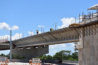 Workers on the flyover bridge that will take westbound Overpass Road traffic onto southbound I-75 (photo 7/6/2022)