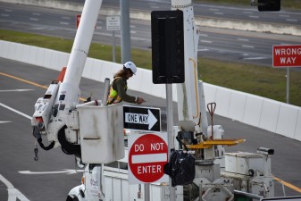 Crews doing work on signs and signals at the intersection of the northbound I-75 exit ramp and Overpass Road (1/13/2023 photo)