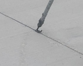 Installing joint sealant in the concrete roadway (1/21/2023 photo)