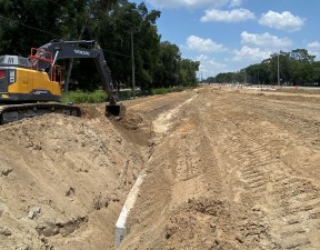 Grading a drainage ditch along new eastbound SR 52, west of Pasadena Road (6/24/2022 photo)
