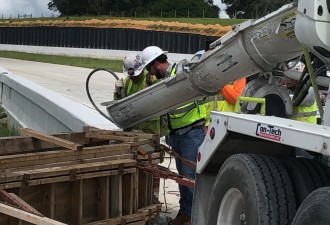 Placing concrete for a traffic barrier along along new SR 52 (7/14/2021 photo)