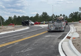A truck with trailer is using the new connector road from CR 52 (old SR 52) to turn west onto new SR 52 (5-5-2023 photo)