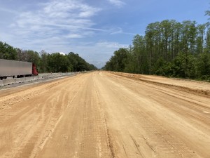Looking east at embankment placement and compaction of new eastbound roadway base (4-28-2023 photo)