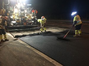 Crews do handwork finishing on freshly placed asphalt