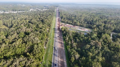 Looking northwest over US 98, north of W Socrum Loop Road, with storm water pond construction on the right (8-29-2025 photo)