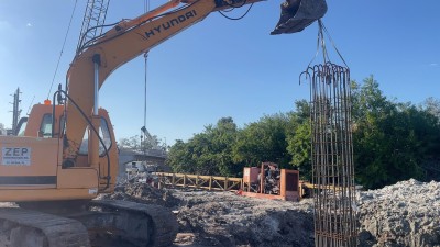 Excavator places rebar cage (March 2026 photo)