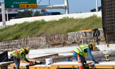 Workers prepare forms for noise barrier wall