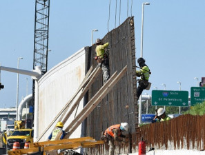 Workers tie steel for noise barrier wall