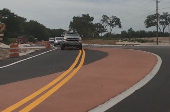 Driving north on US 98 at the roundabout construction at Trilby Road. Traffic is in a temporary alignment, using some of the roundabout's red concrete apron as the east side is built. (July 2, 2020 photo)