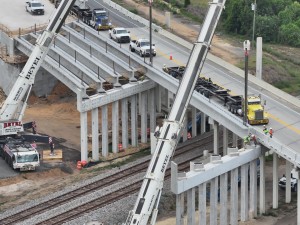 Setting a concrete I-beam for a new US 98 bridge over the railroad tracks (5-12-2026 photo)