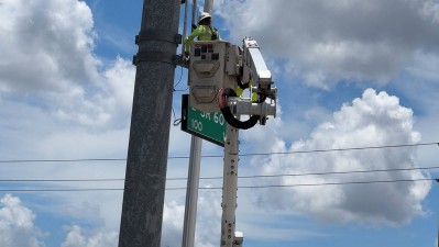 Image showing crews in bucket truck installing highway sign on SR 60 and SR 39 (Photo May 2026)