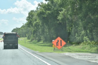 Traffic is directed by the sign to merge right for a left lane closure ahead (7-21-2025 photo)