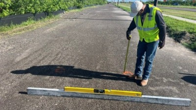Checking surface of finished base with stringline and level at north end of project (August 2026 photo)