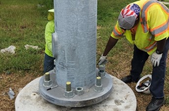 Bolting the pole onto the foundation base (8/17/2022 photo)