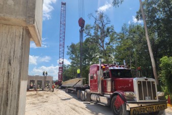 Preparing to lift a bridge beam from the transport to its position over the Withlacoochee River (8-18-2026 photo)