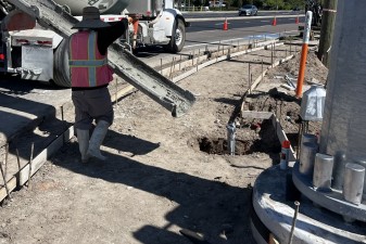 Placing concrete for a pedestrian signal base and sidewalk (10-14-2025 photo)