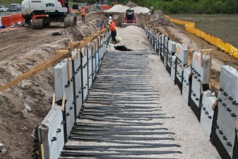 Building the retaining wall panel by panel for the trail bridge approach (4-9-2026 photo)