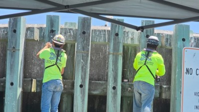 Crews perform maintenance on the dolphins protective barriers in the water (May 2026)