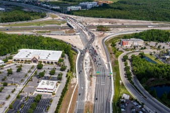 Looking northwest over SR 56 on the east side of I-75 at traffic in the new diverging diamond interchange pattern (5/17/2022 photo)